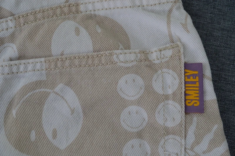 H&M x Smiley Damen High Waist Jeans mit Allover-Print in BeigeWeiß – Gr. 36