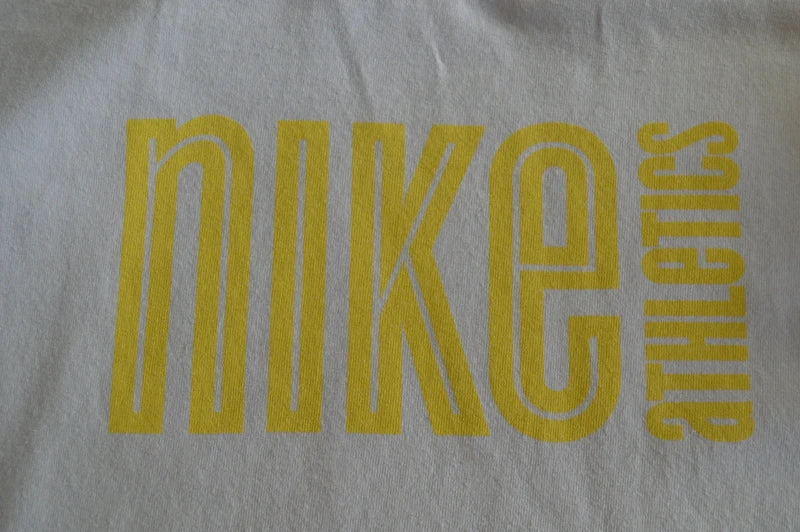Nike Athletics – Vintage T-Shirt "Silver Tag" in Weiß / Gelb – Gr. L (Guter Vintage-Zustand)