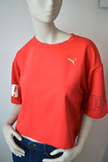 PUMA – Damen Cropped T-Shirt Rebel Tee in Orangerot mit Ärmel-Prints – Gr. S (Sehr guter Zustand)