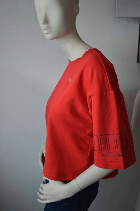 PUMA – Damen Cropped T-Shirt Rebel Tee in Orangerot mit Ärmel-Prints – Gr. S (Sehr guter Zustand)