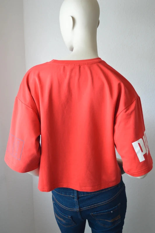 PUMA – Damen Cropped T-Shirt Rebel Tee in Orangerot mit Ärmel-Prints – Gr. S (Sehr guter Zustand)
