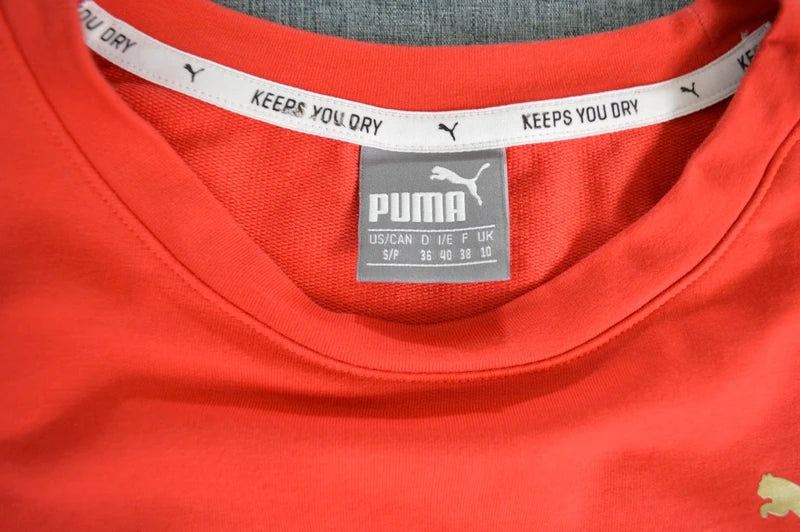 PUMA – Damen Cropped T-Shirt Rebel Tee in Orangerot mit Ärmel-Prints – Gr. S (Sehr guter Zustand)