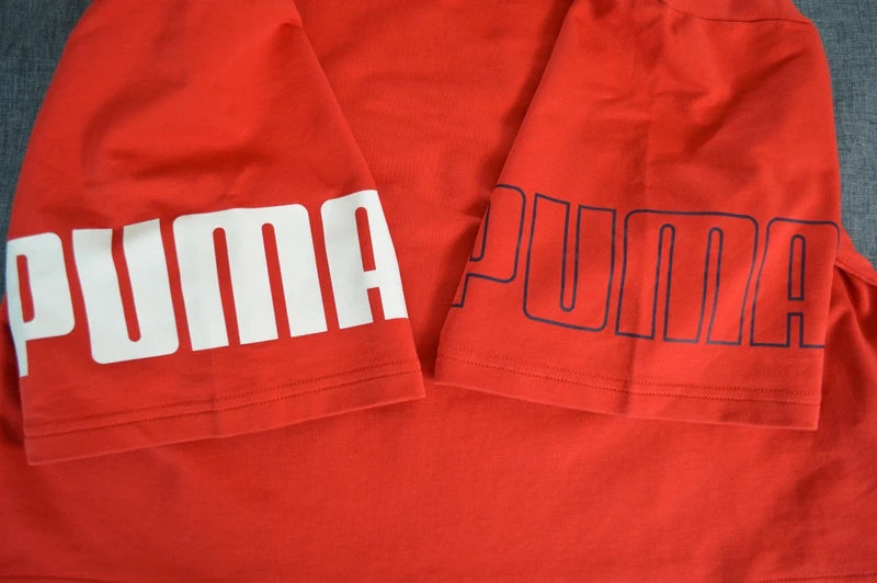 PUMA – Damen Cropped T-Shirt Rebel Tee in Orangerot mit Ärmel-Prints – Gr. S (Sehr guter Zustand)